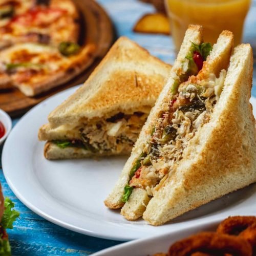 jpeg-optimizer_club-sandwich-chicken-breast-lettuce-cheese-toast-bread-tomato-cucumber-french-fries-side-view